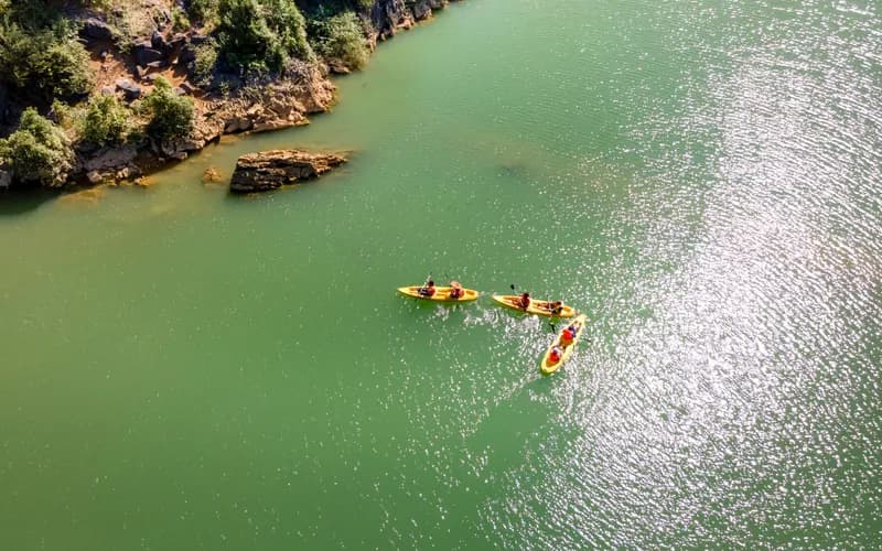 Kayakers paddling the Nam Ou River between limestone cliffs near Nong Khiaw