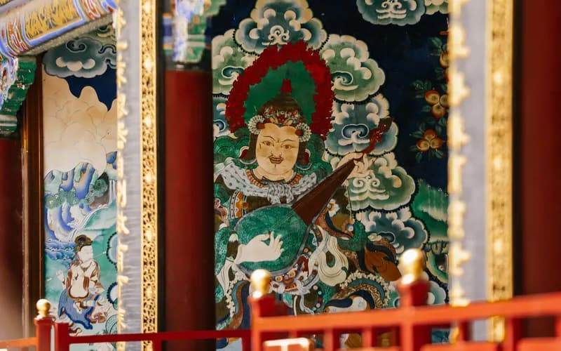 interior mural of two figures leaning close inside Wat Phumin temple