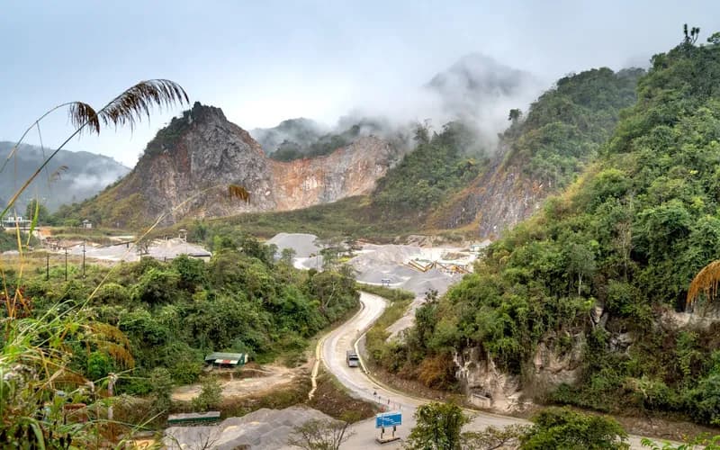 winding mountain road climbing through misty forested hills near Pua