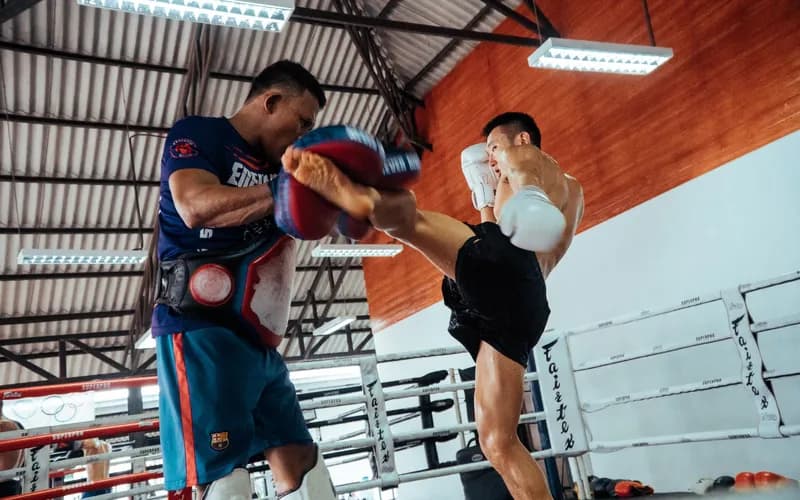 Des boxeurs de Muay Thaï s'entraînant dans une salle en plein air au crépuscule