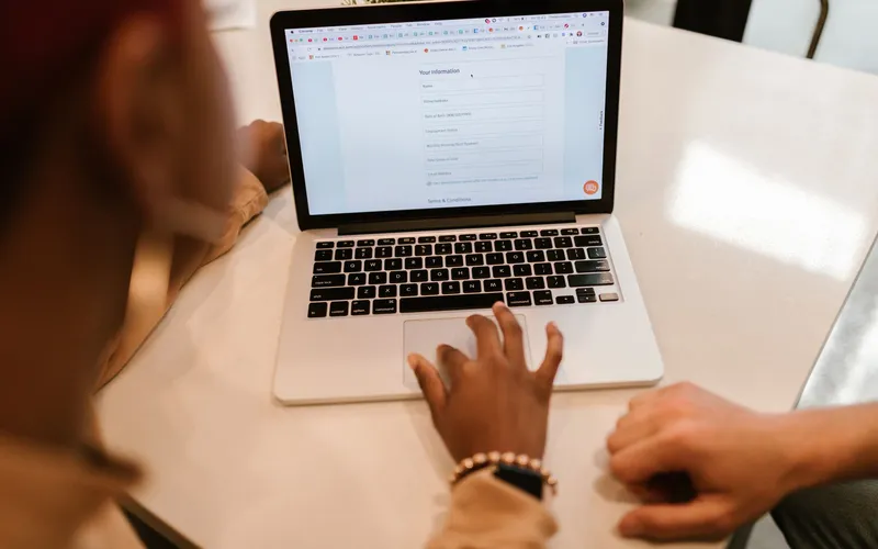 a traveller filling in an online visa form on a laptop