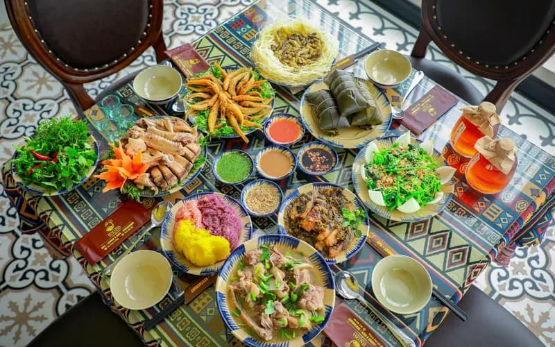 Un ensemble de petits plats de cuisine royale vietnamienne disposés sur une table en bois laqué — bols en céramique, papillotes en feuille de bananier