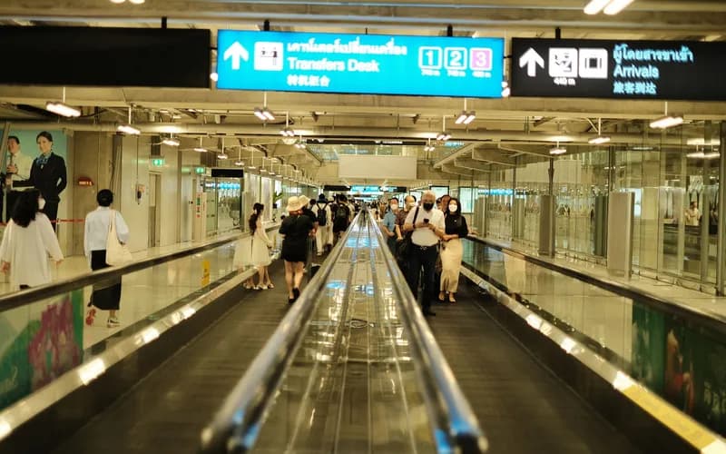 Le hall des arrivées d'un grand aéroport international au Vietnam, des voyageurs progressant dans un large couloir vers le contrôle de l'immigration