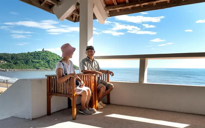 Un pavillon de yoga ouvert et calme dans une retraite côtière du centre du Vietnam, plancher en bois, rideaux blancs légers animés par la brise marine